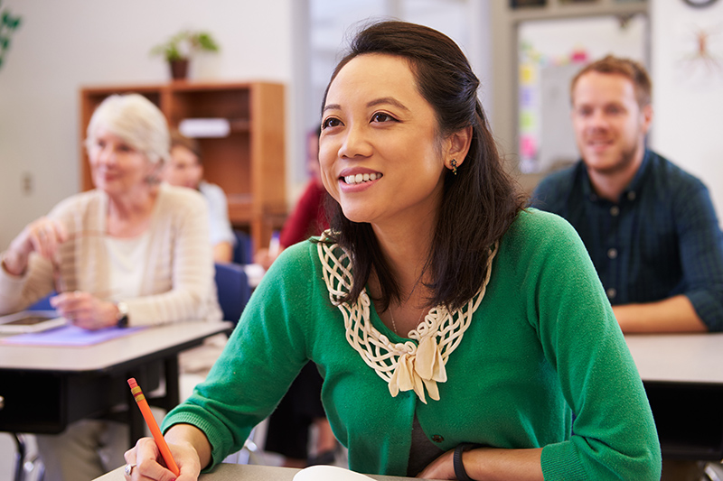 A teacher speaks with two students